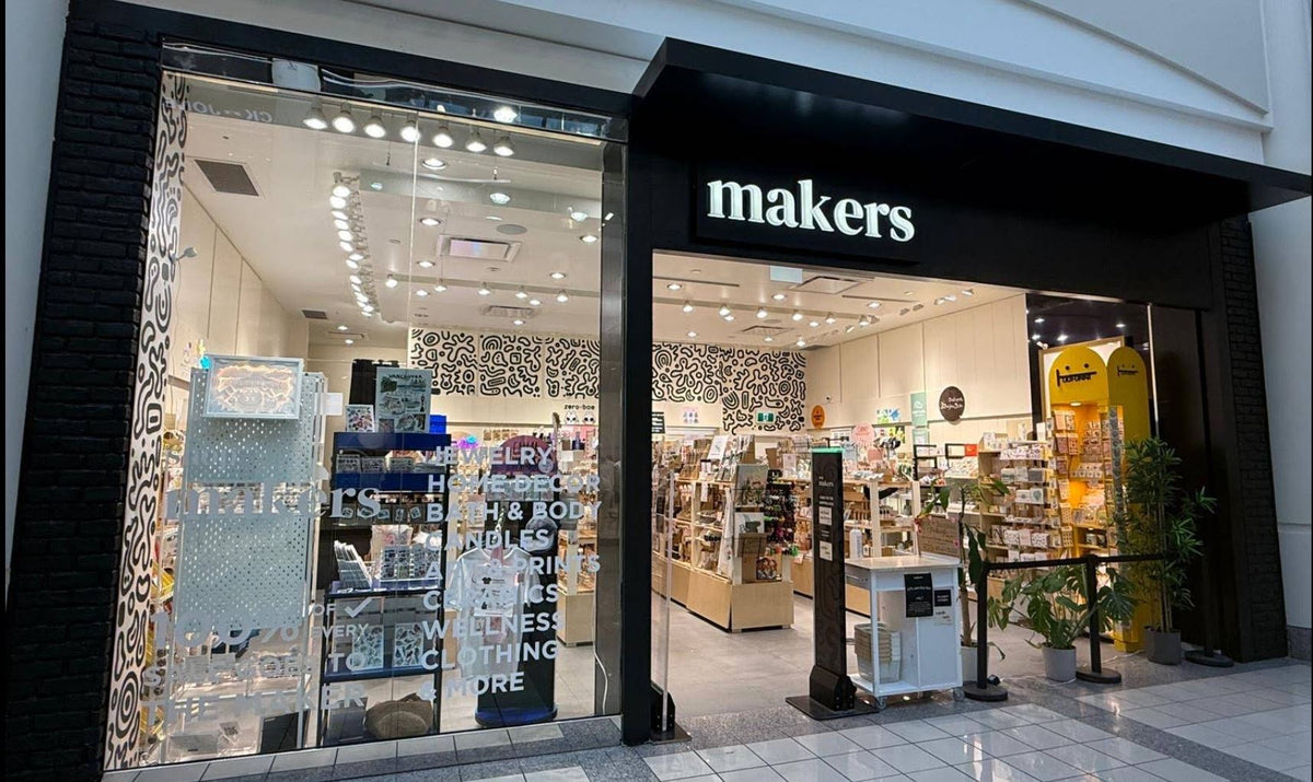 Storefront of a 'makers' metrotown store with glass door and visible interior.