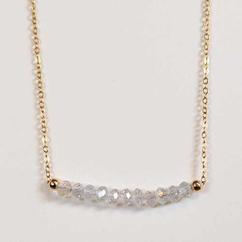 April birthstone necklace with faceted white topaz beads on a gold chain