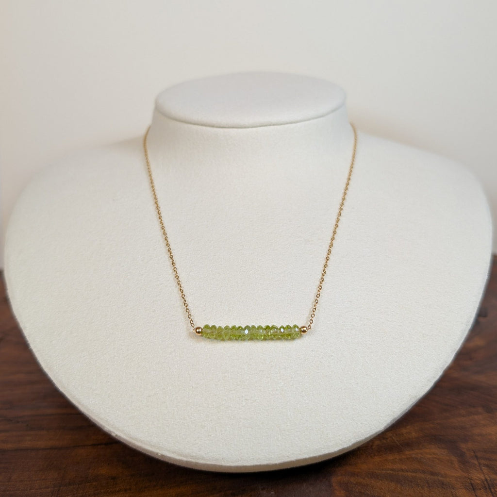 August peridot birthstone necklace on a jewelry display bust