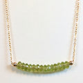 August birthstone necklace with faceted peridot beads on a gold chain