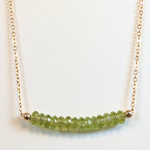 August birthstone necklace with faceted peridot beads on a gold chain