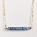 December birthstone necklace with faceted blue topaz beads on a gold chain