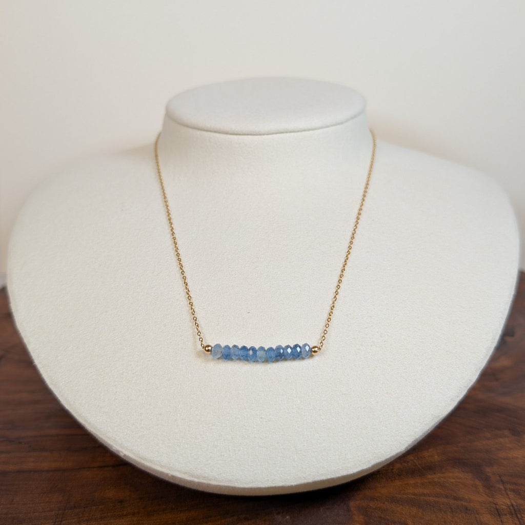 December blue topaz birthstone necklace on a jewelry display bust
