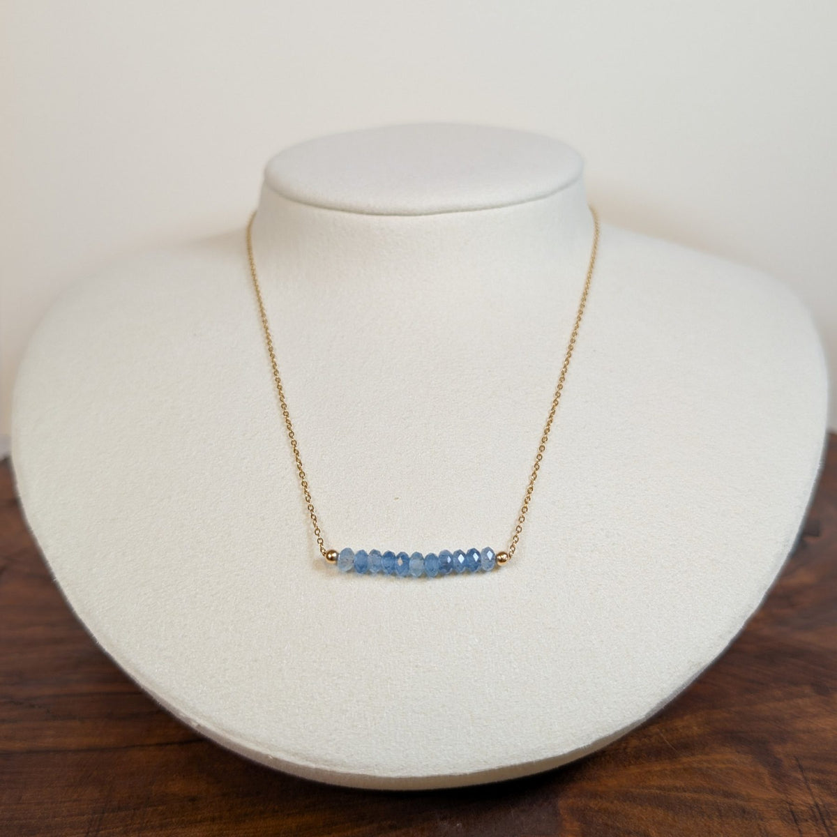 December blue topaz birthstone necklace on a jewelry display bust