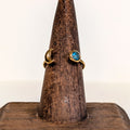 Eclipse Ring with a blue copper turquoise cabochon and a gold crescent moon, on a wooden ring stand