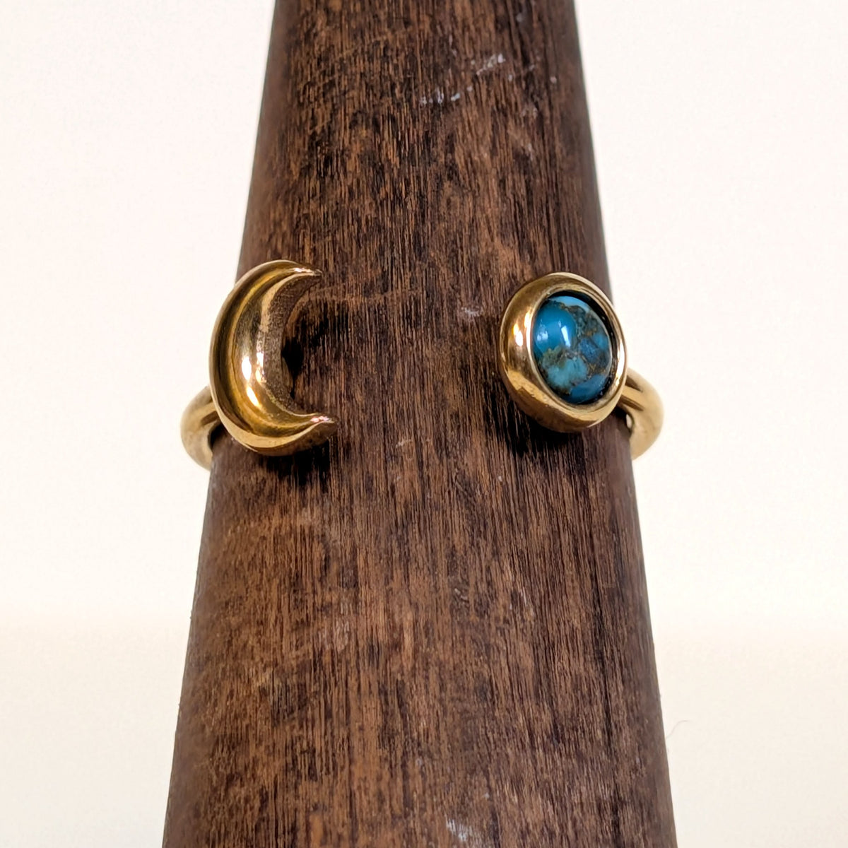 Close-up of the Eclipse Ring showing the gold crescent moon and the bezel-set turquoise