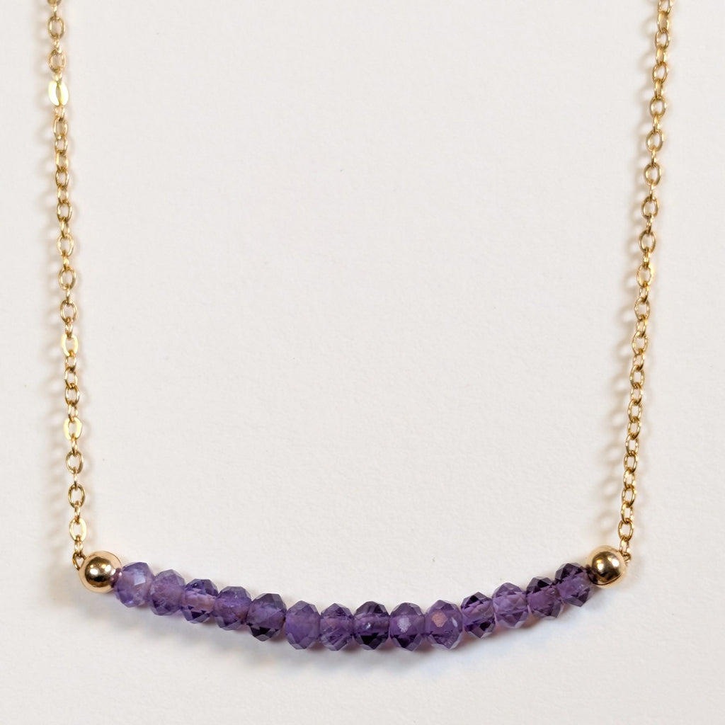 February birthstone necklace with faceted amethyst beads on a gold chain