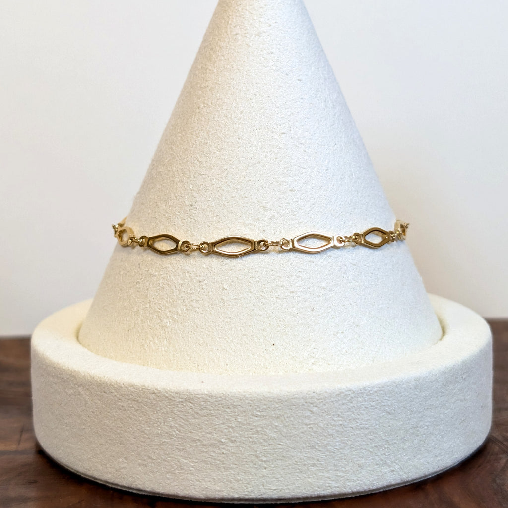 Golden Links bracelet with slender open marquise links, shown on a display cone