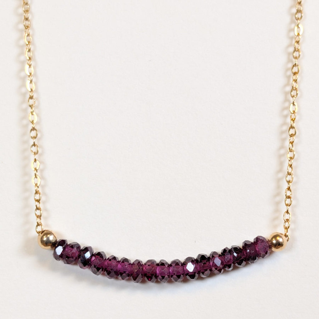 January birthstone necklace with faceted garnet beads on a gold chain