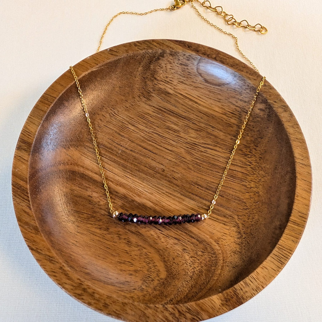 January garnet birthstone necklace in a wooden dish