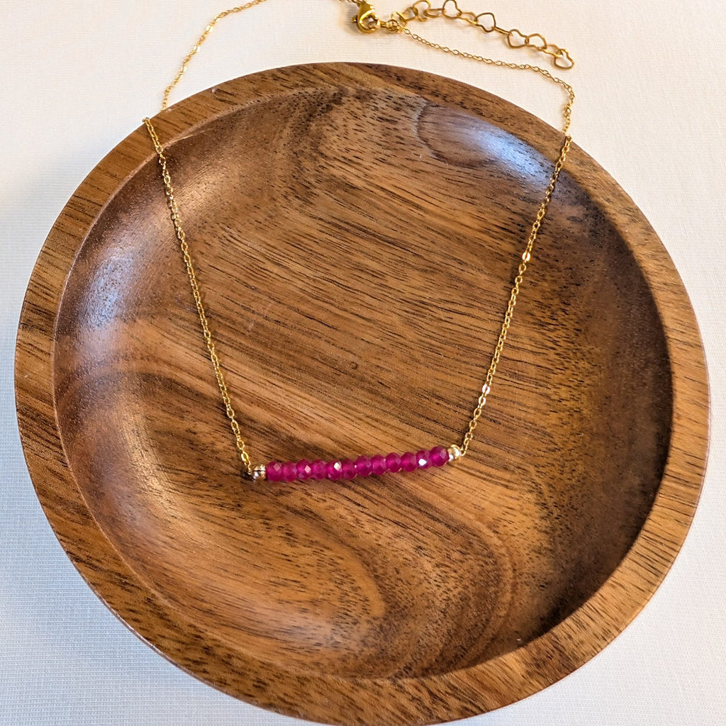 July ruby birthstone necklace in a wooden dish