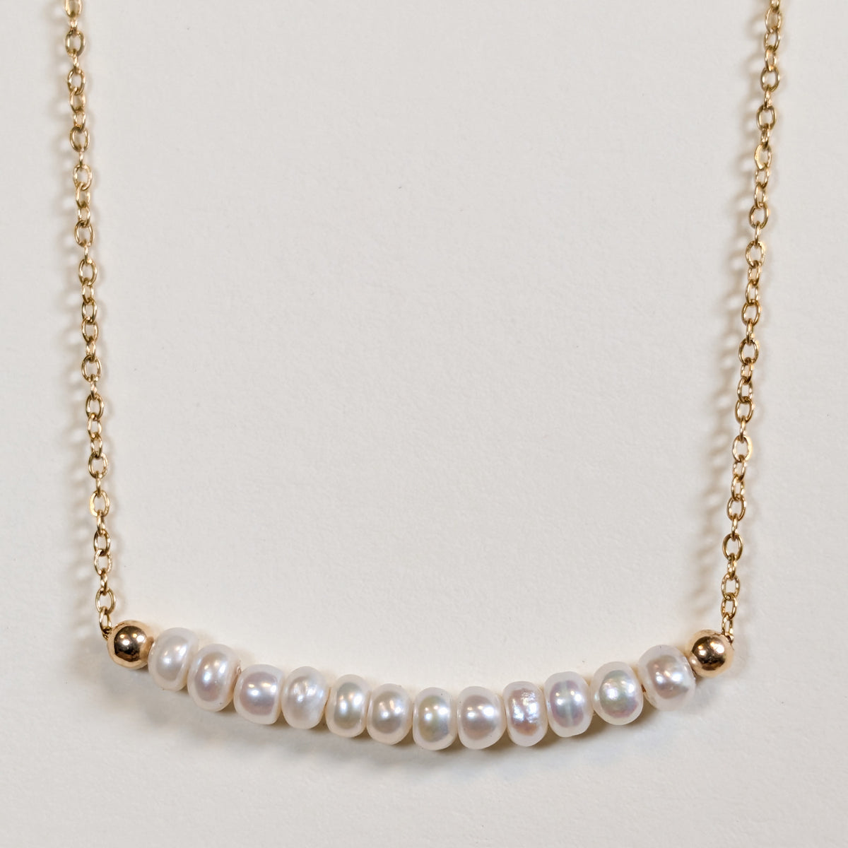 June birthstone necklace with freshwater pearl beads on a gold chain