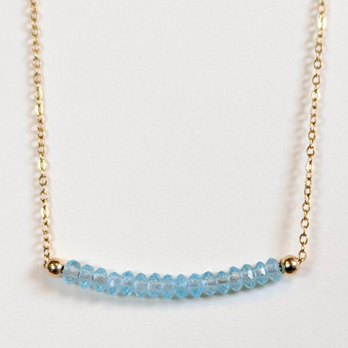 March birthstone necklace with faceted aquamarine beads on a gold chain