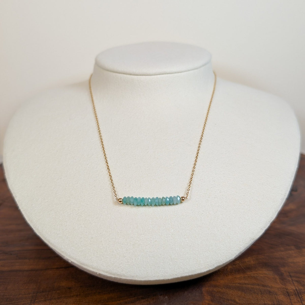 May emerald birthstone necklace on a jewelry display bust