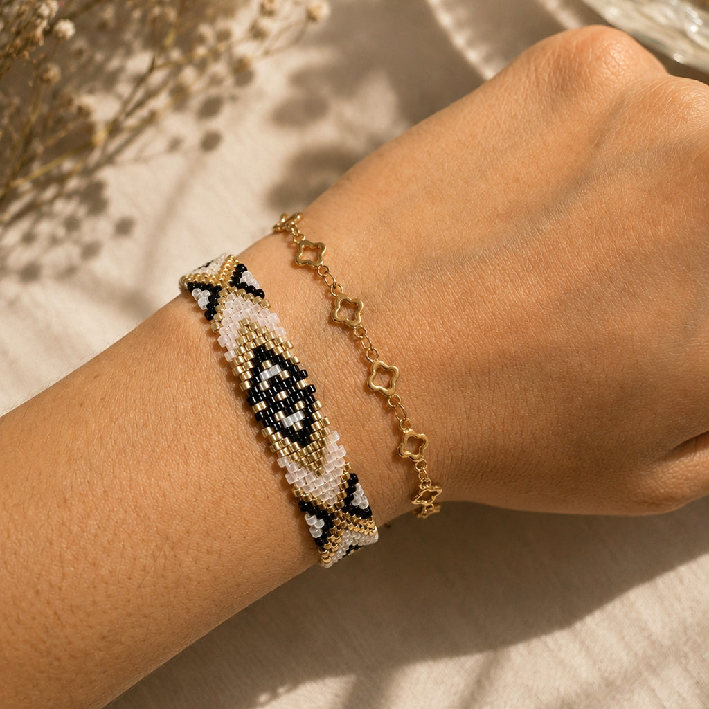 Model wearing the Woven Roots Ivory handwoven Miyuki bracelet with a gold chain bracelet