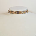 Wide Miyuki beaded choker band in gold, bone and grey with dark diamonds, on a white display bust