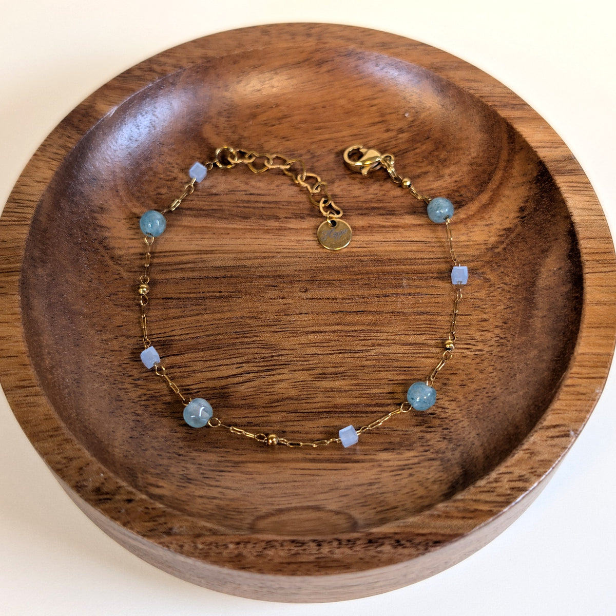 Ocean Mist agate bead bracelet with lobster clasp and heart-link extender, shown in a walnut dish