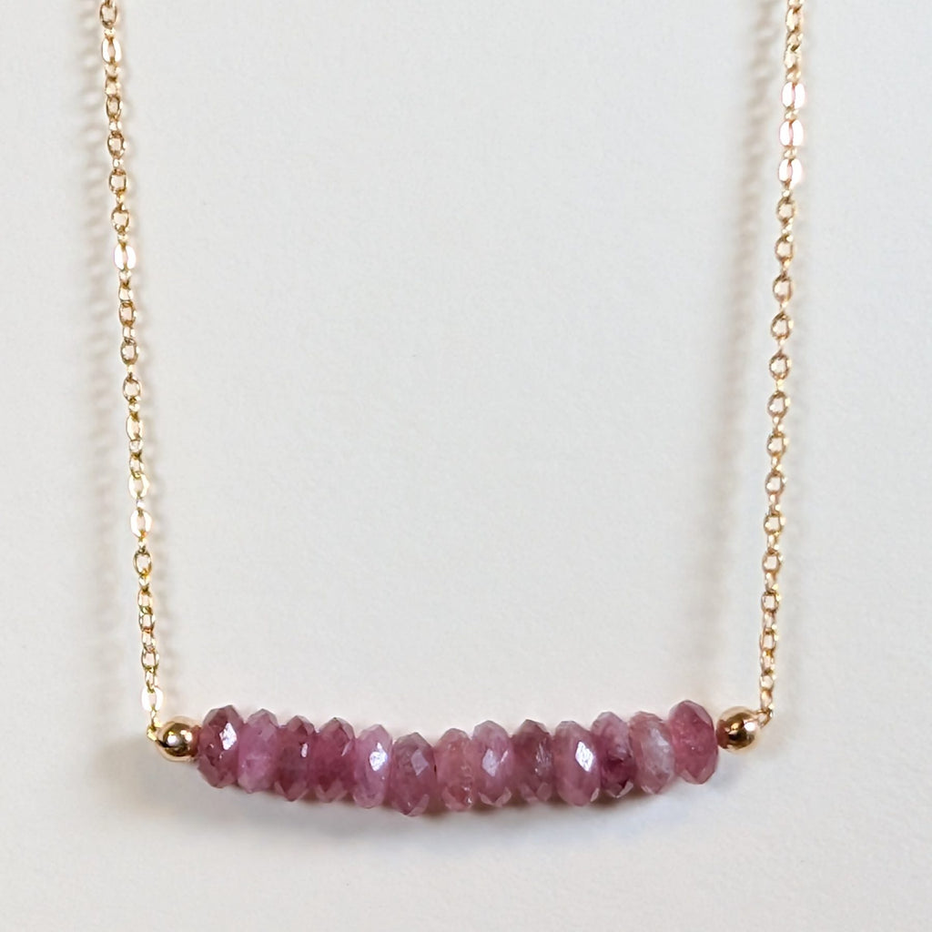 October birthstone necklace with faceted pink tourmaline beads on a gold chain