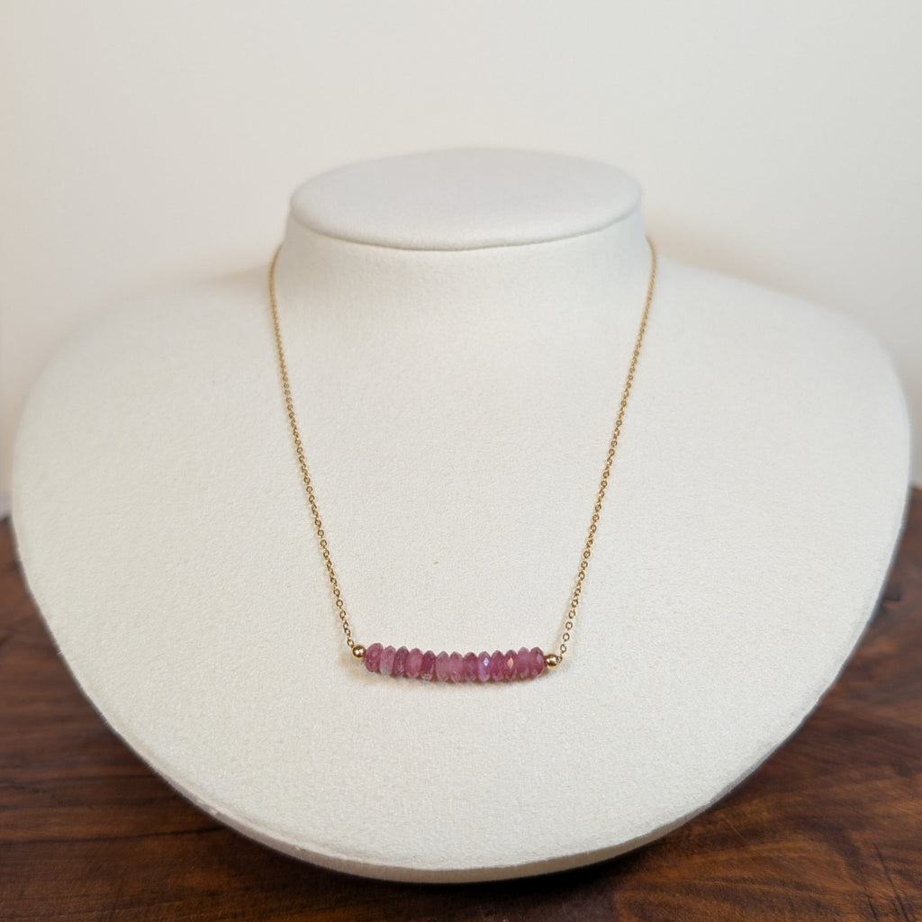 October tourmaline birthstone necklace on a jewelry display bust