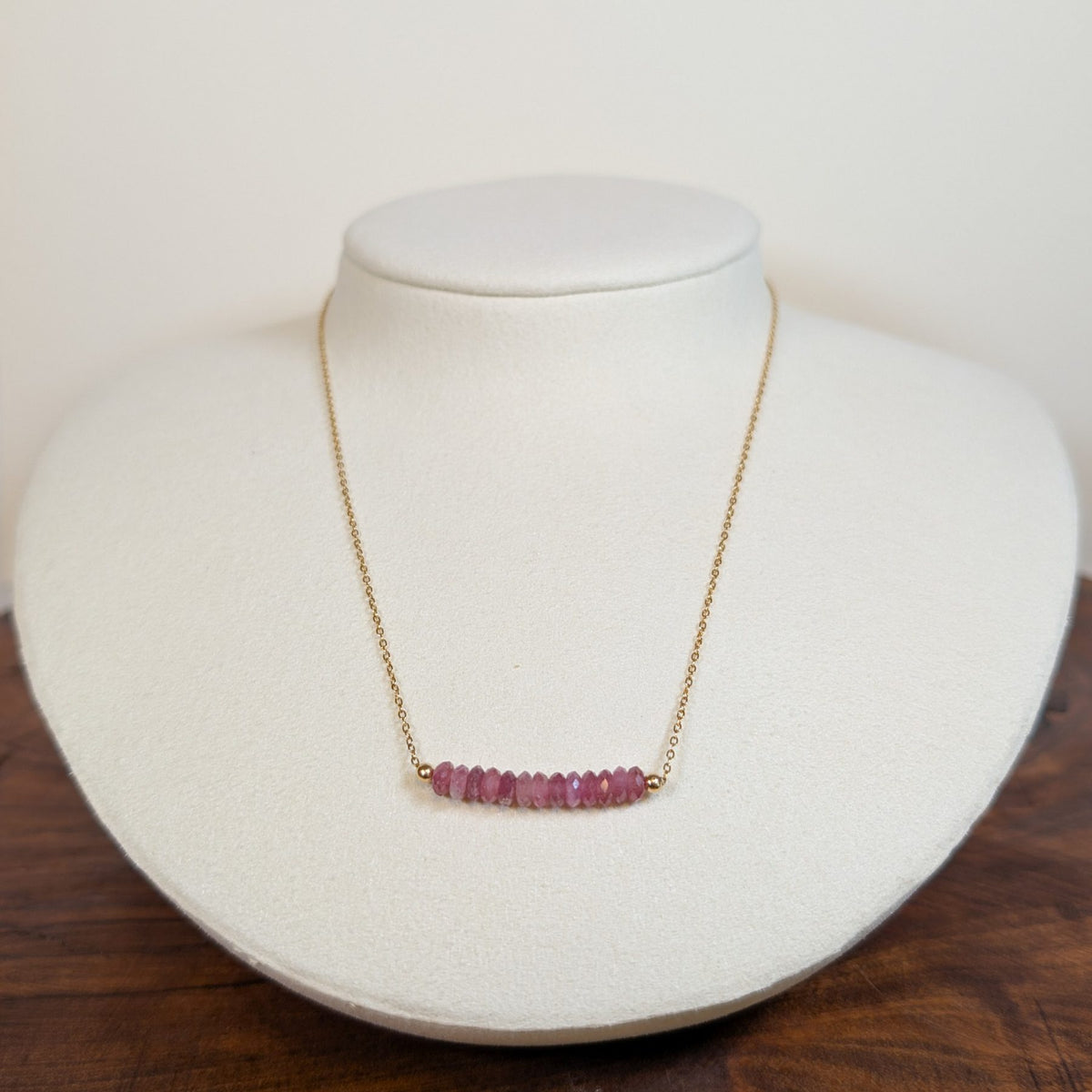 October tourmaline birthstone necklace on a jewelry display bust