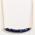 September birthstone necklace with faceted sapphire beads on a gold chain