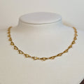 Gold-tone stainless steel choker chain of open heart links on a white display bust