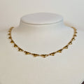 Gold-tone stainless steel choker chain of solid polished heart links on a white display bust