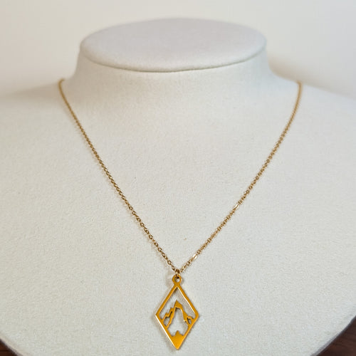 Gold-tone stainless steel necklace with a cut-out mountain range in a diamond frame on a white display bust