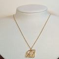 Gold-tone stainless steel necklace with a cut-out origami bear pendant on a white display bust